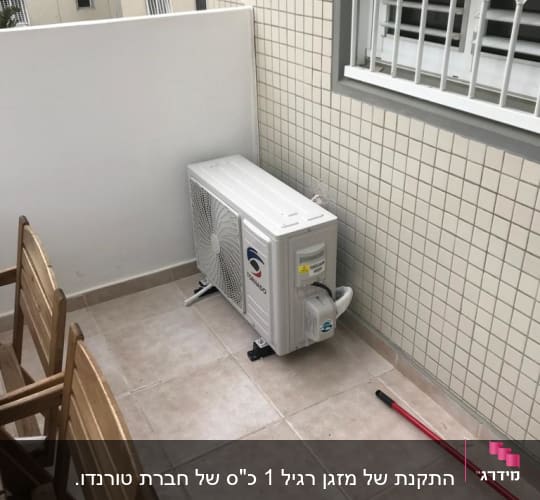 יחידת מזגן חיצונית מותקנת על מרפסת מרוצפת